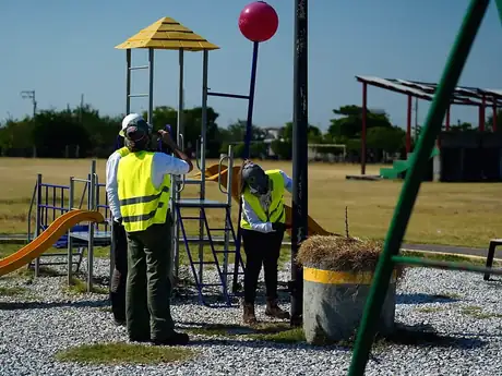 Voluntarios corporativos rehabilitando los juegos del parque comunitario