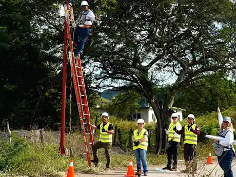 Técnico y voluntarios instalando una luminaria solar sobre un poste en La Blanca, Oaxaca