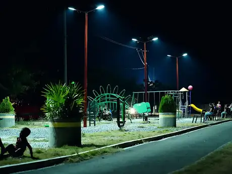 Familias y niños en el parque comunitario iluminado por las nuevas lámparas solares