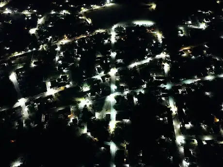 Vista aérea nocturna de las calles de la comunidad iluminadas tras la instalación de 60 lámparas solares